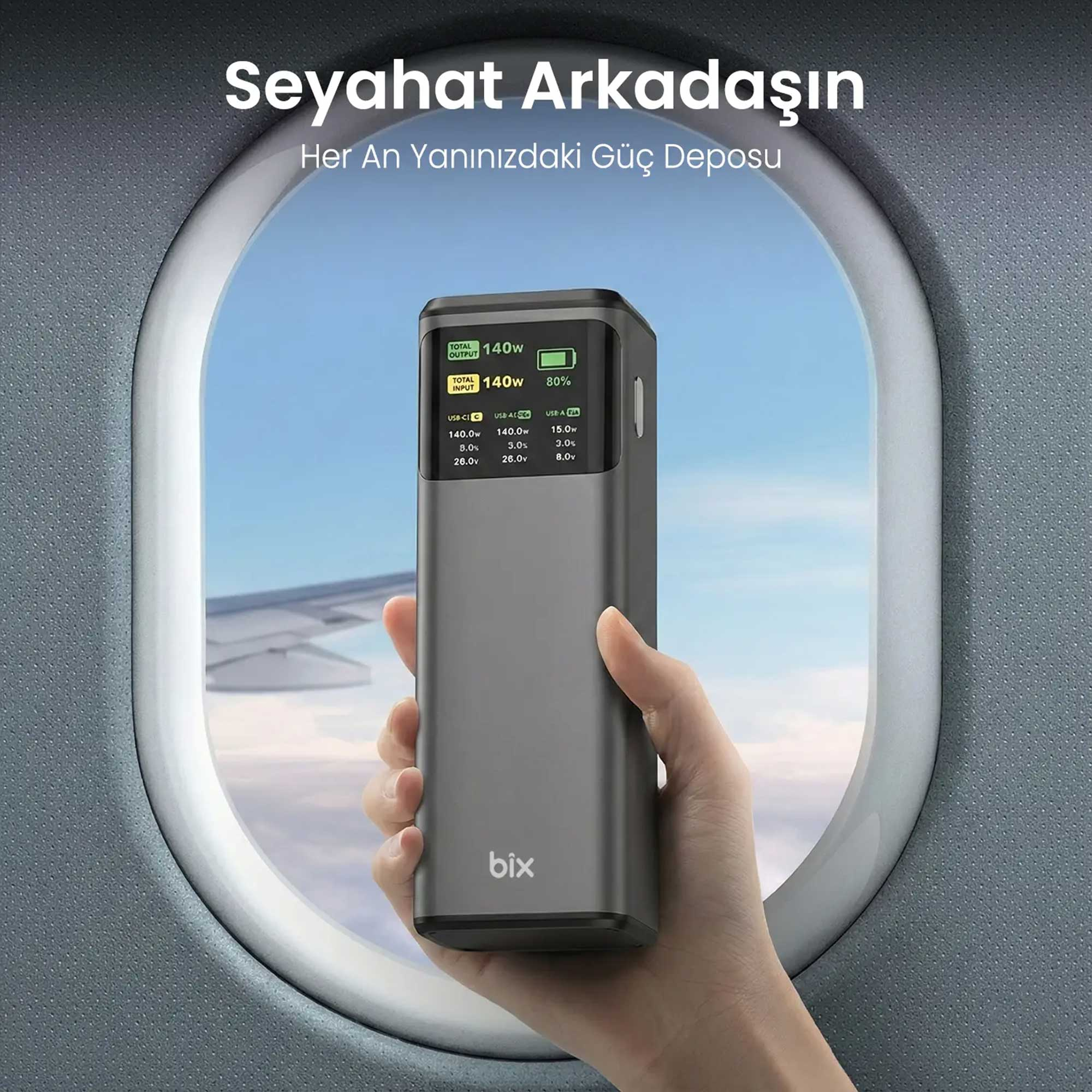 Gri powerbank uçak penceresi yanında tutuluyor. Ekran 140W ve %80 şarj gösteriyor.
