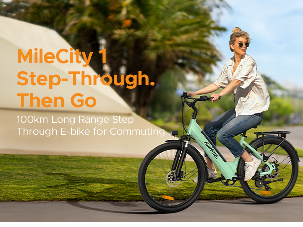 Donna in sella a una e-bike verde menta con telaio ribassato all'aperto.