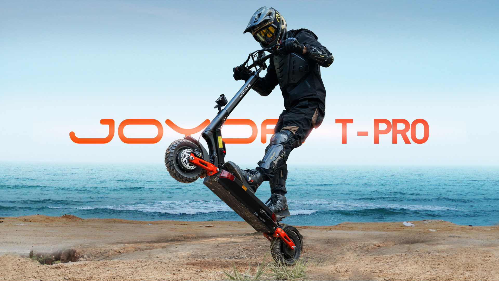 Una persona su uno scooter elettrico fa un'impennata sulla spiaggia.