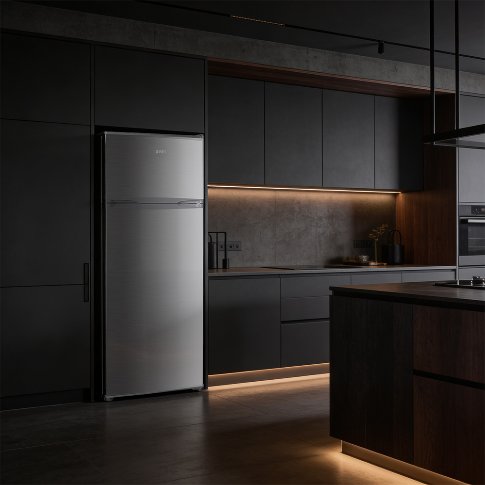 Un refrigerador plateado en una cocina moderna y oscura con gabinetes negros y luz de acento.
