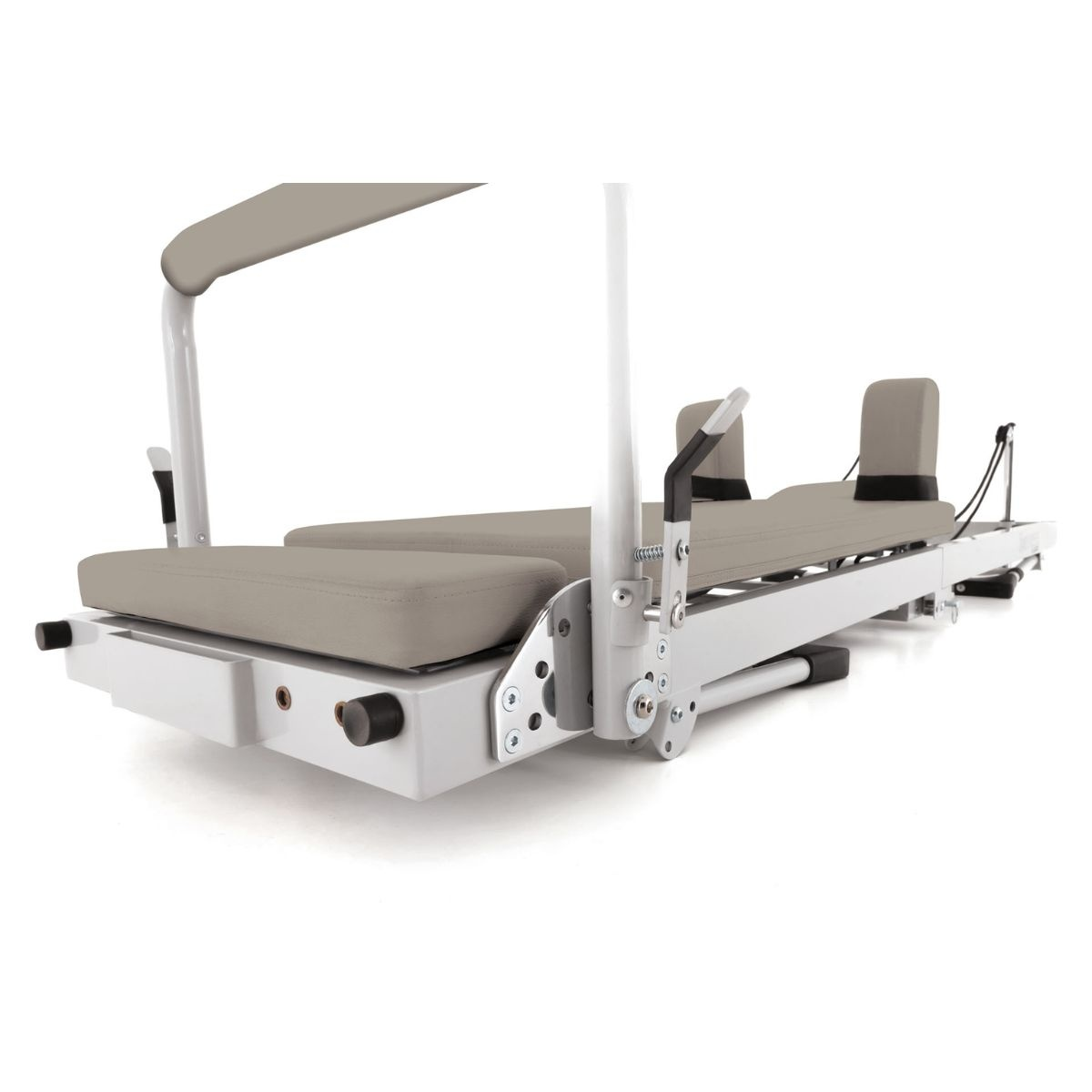 A Pilates reformer with padded surfaces and a metal frame, set against a white background.