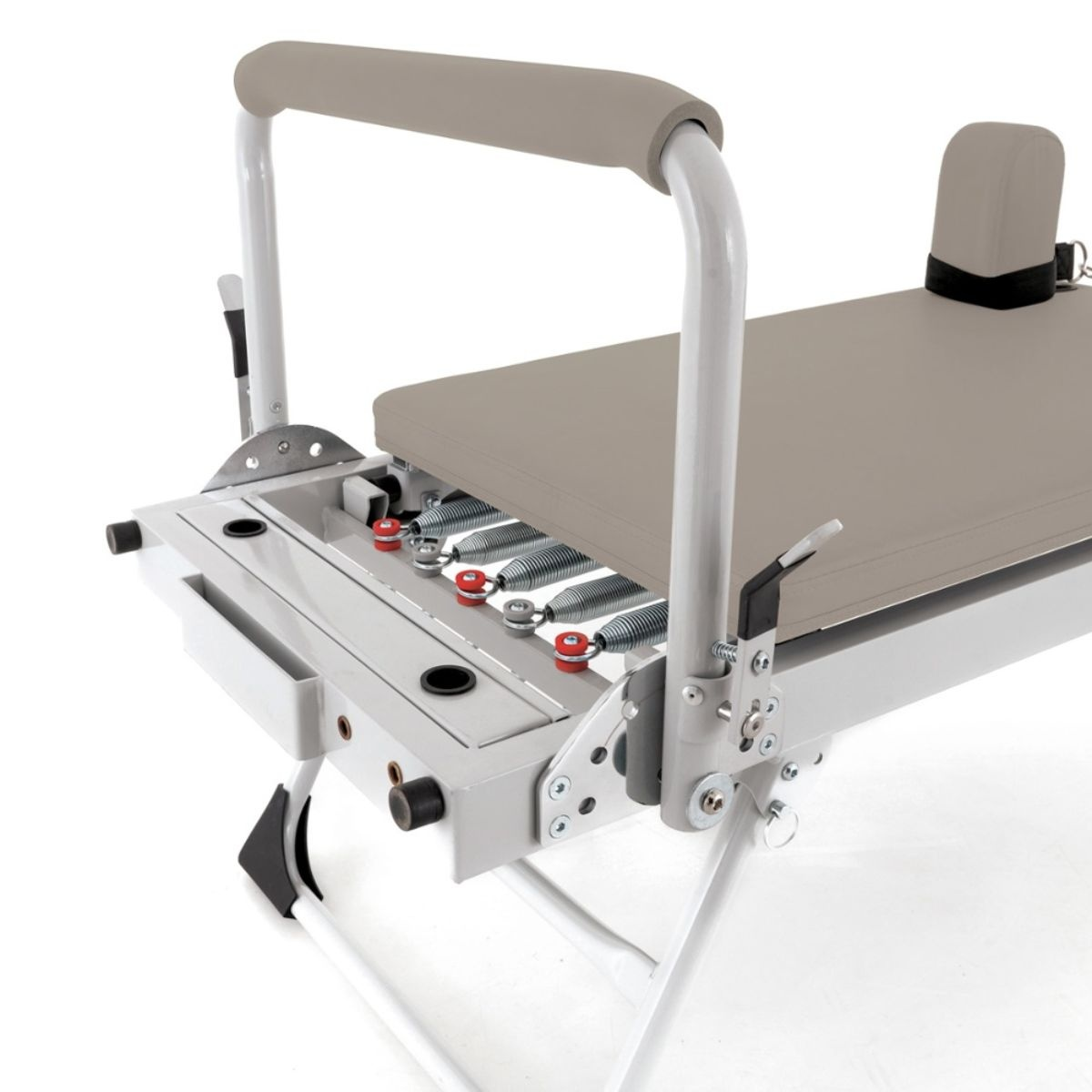 Pilates reformer with padded surface, handles, and springs.