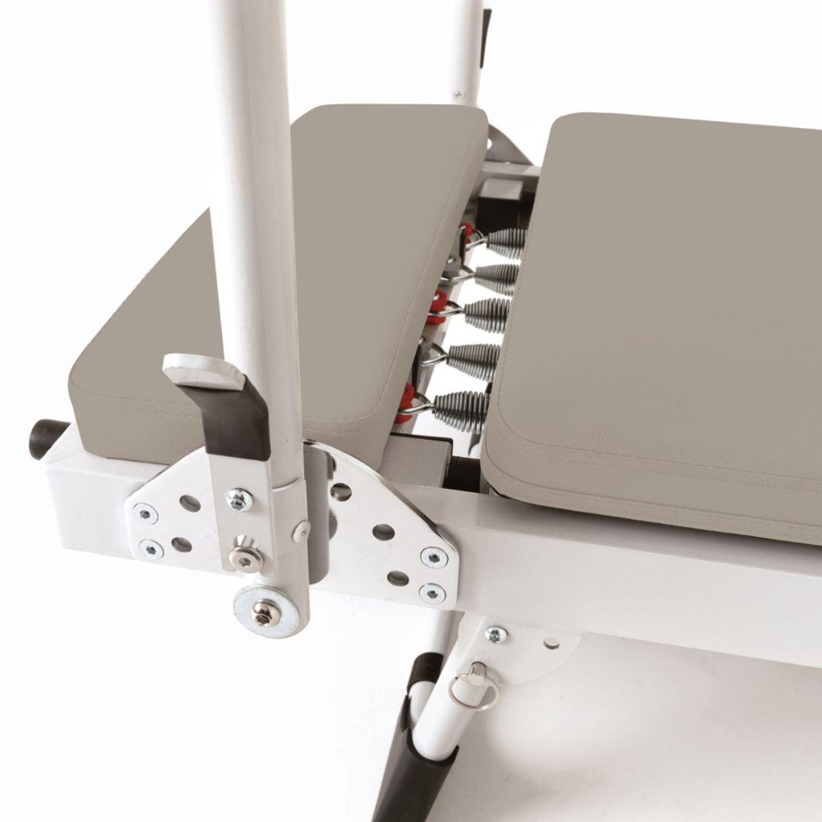 Close-up of a white exercise bench with gray padding and springs.