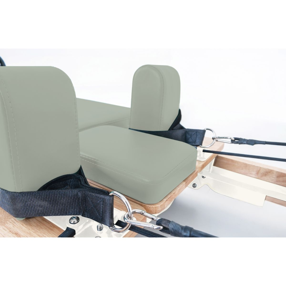 Gray upholstery with straps and ropes on a Pilates machine.
