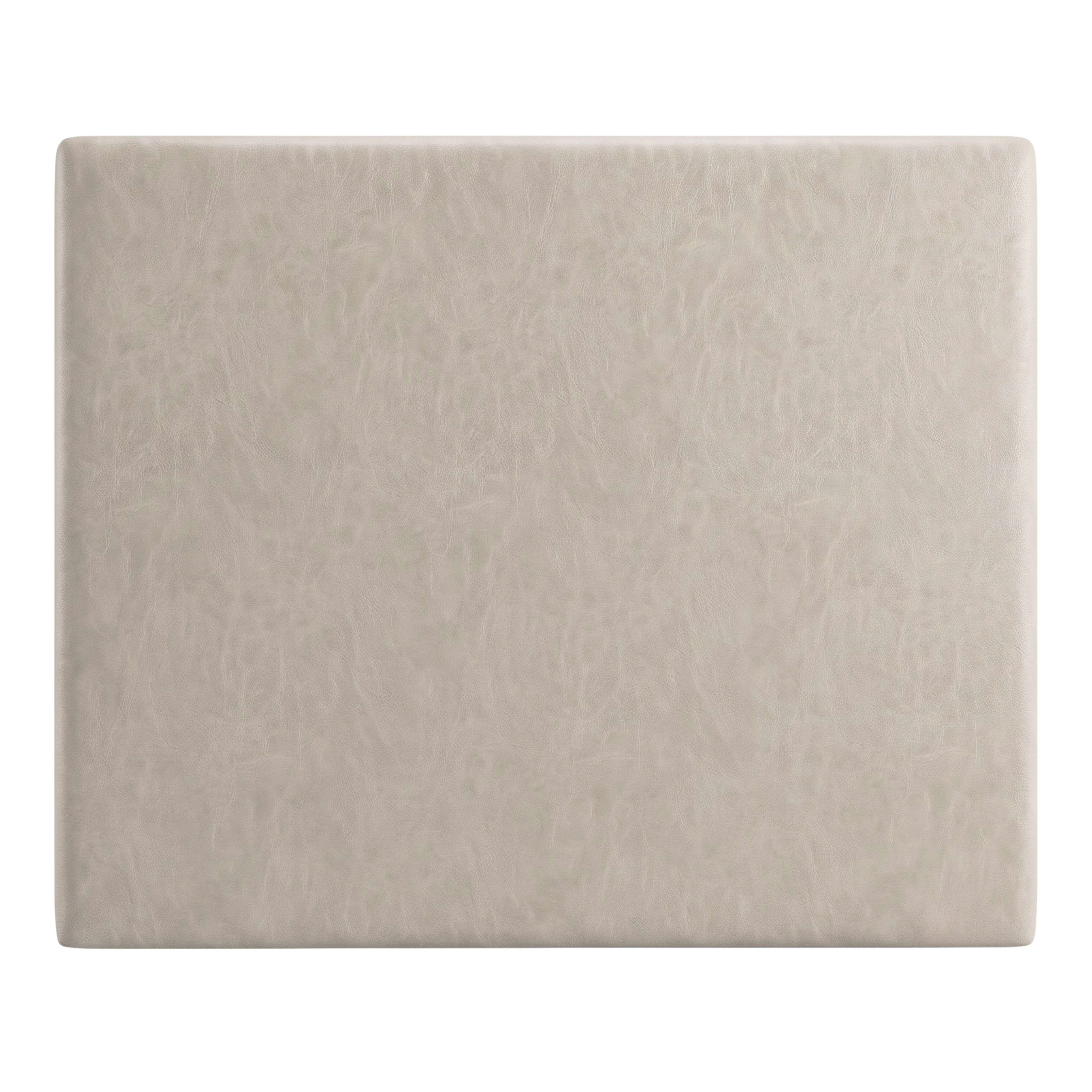Un cojín rectangular de cuero gris claro con superficie texturizada.