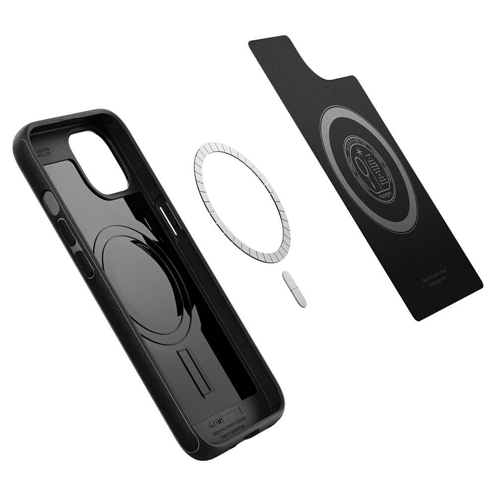 Custodia nera per telefono, anello magnetico e piastra metallica su sfondo bianco.