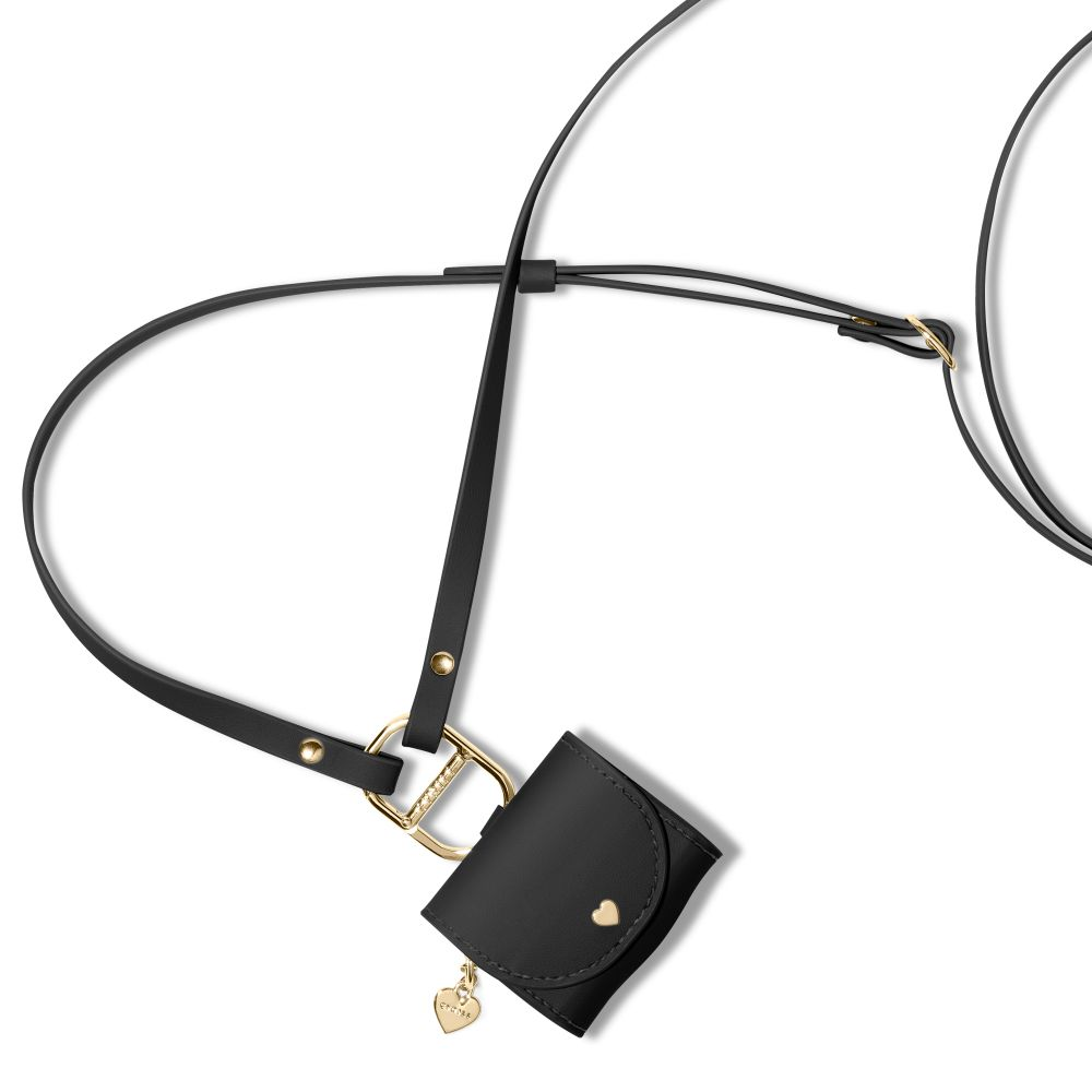 Piccola custodia nera con ciondolo a cuore e hardware dorato, su un cinturino nero.