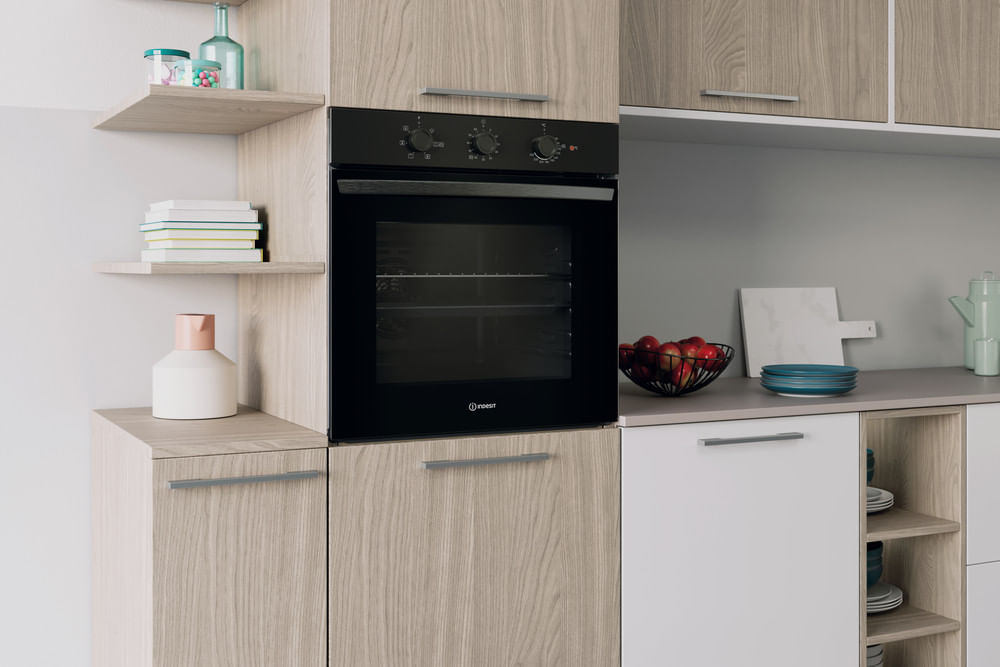 Una cucina moderna con forno da incasso, mobili in legno e mensole.
