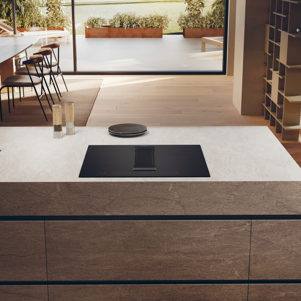 Isola cucina moderna con piano a induzione nero e cappa integrata.