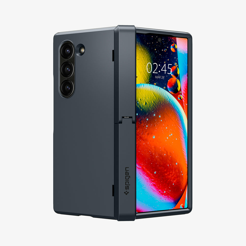 Telefono pieghevole grigio scuro con tre fotocamere e schermo colorato.