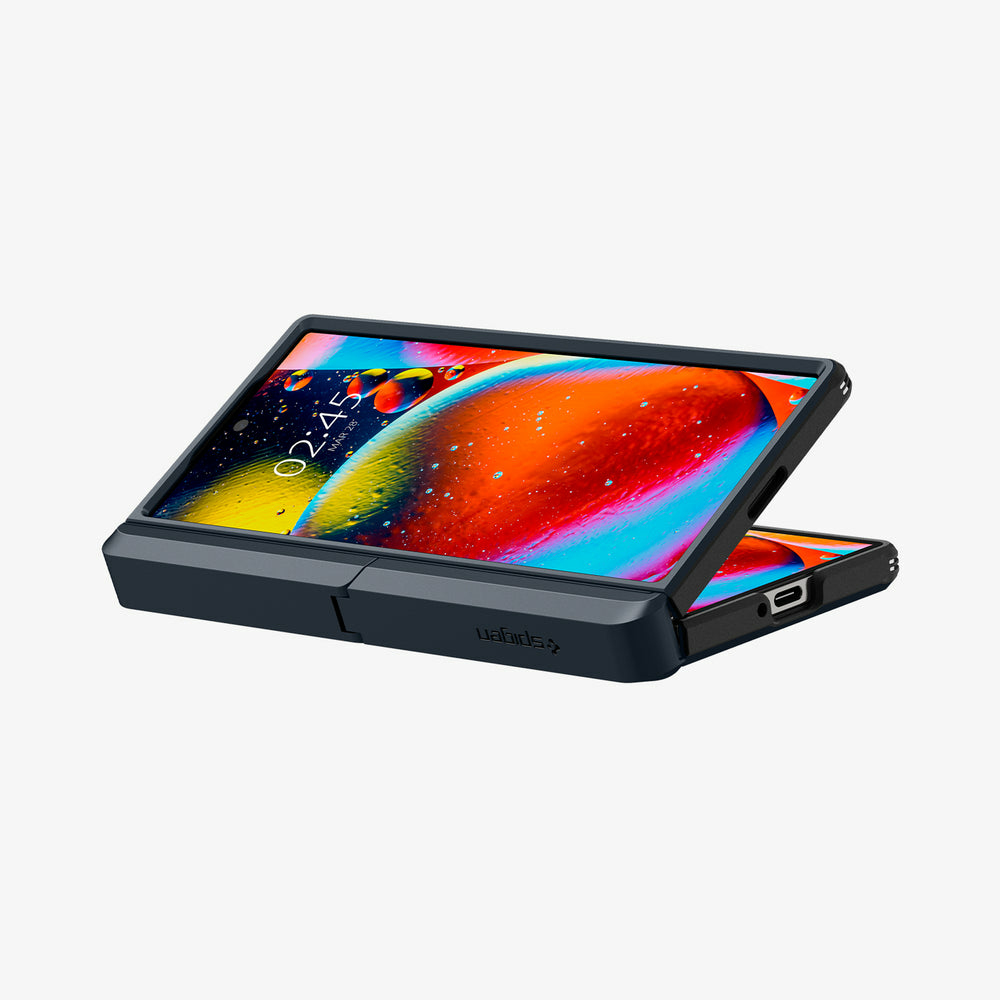 Un telefono pieghevole scuro aperto con uno sfondo colorato.