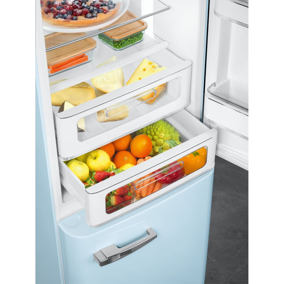 Un refrigerador abierto con varios cajones llenos de frutas, verduras y queso.