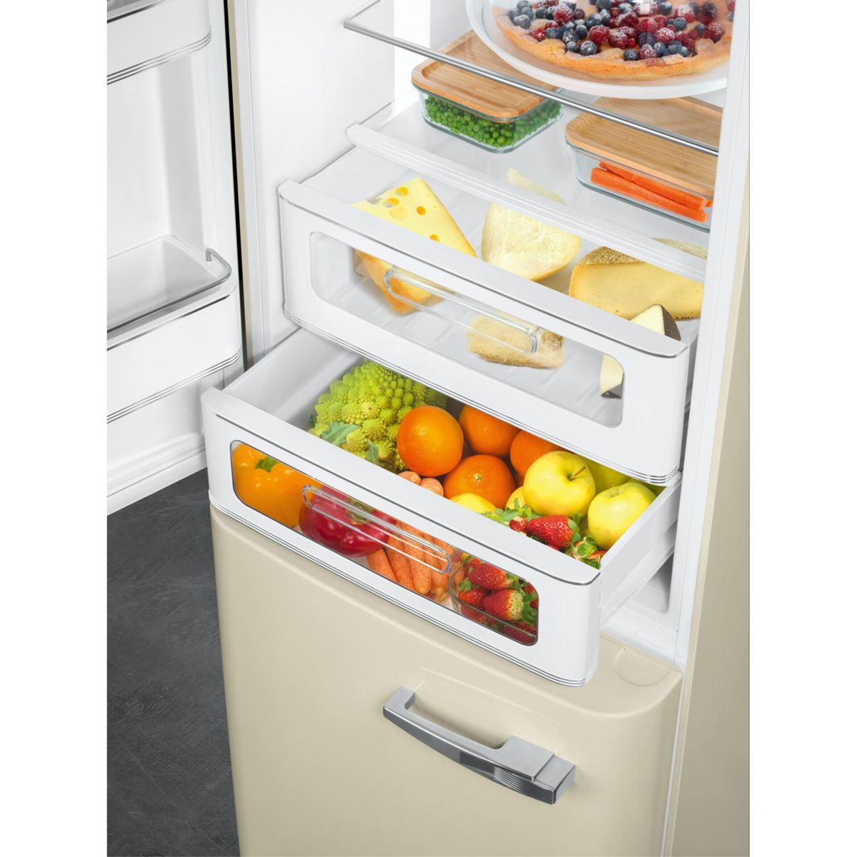 Vista interior de un refrigerador abierto con frutas, verduras y queso en cajones.