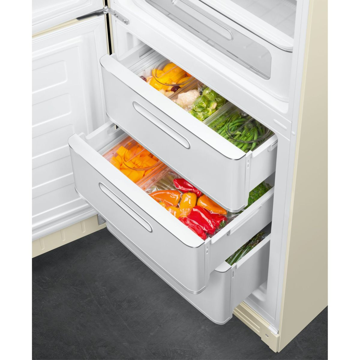 Un refrigerador abierto con tres cajones extraíbles llenos de verduras frescas.