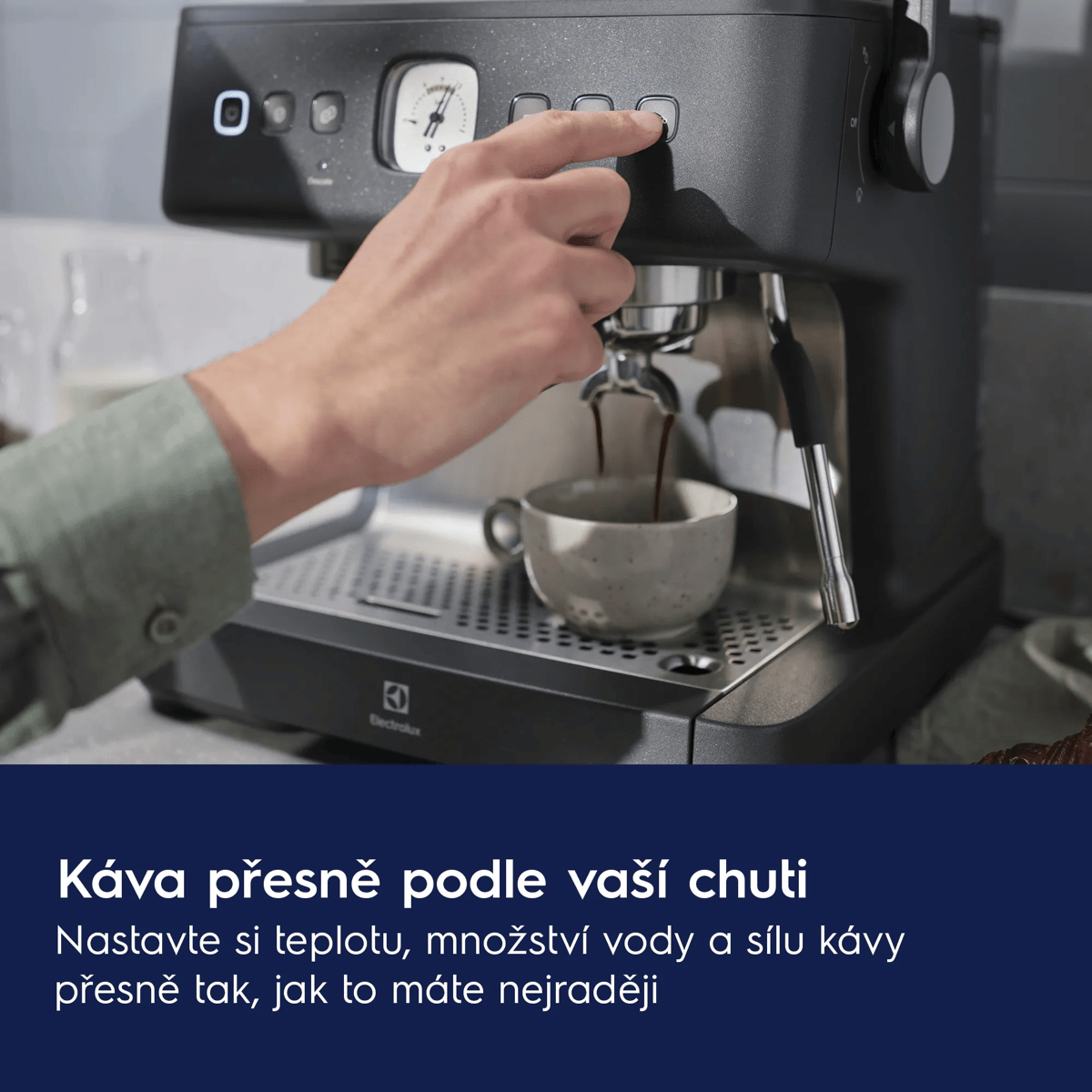 Una mano preme un pulsante su una macchina da caffè mentre il caffè viene erogato in una tazza.