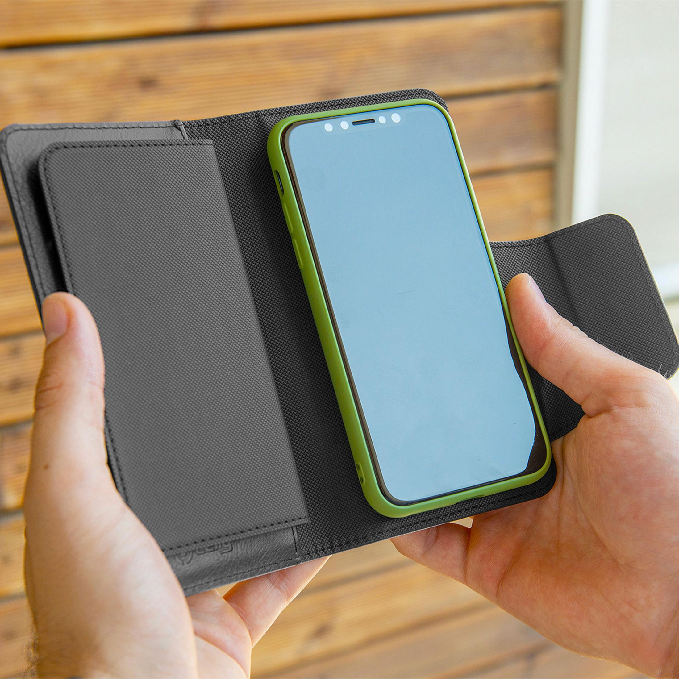 Una persona tiene uno smartphone in una custodia verde all'interno di un portafoglio scuro.