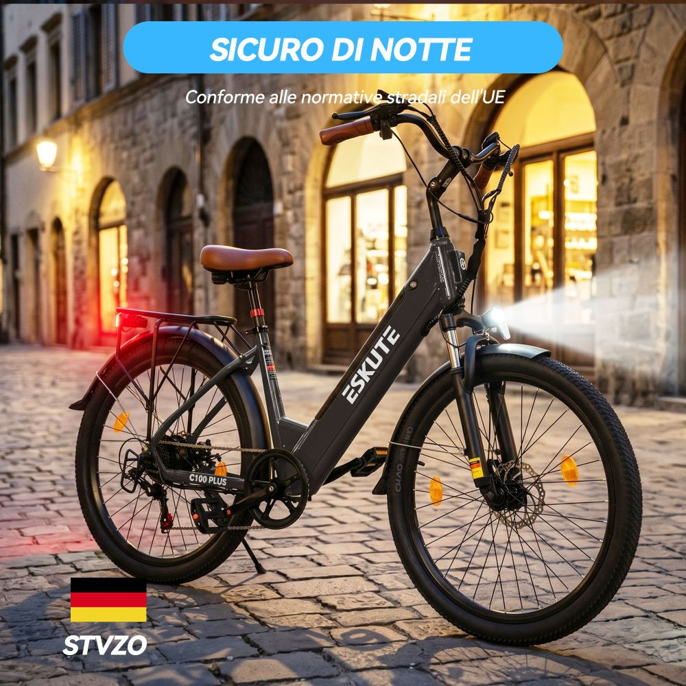 Una e-bike nera è parcheggiata su una strada acciottolata di notte. Le sue luci sono accese.