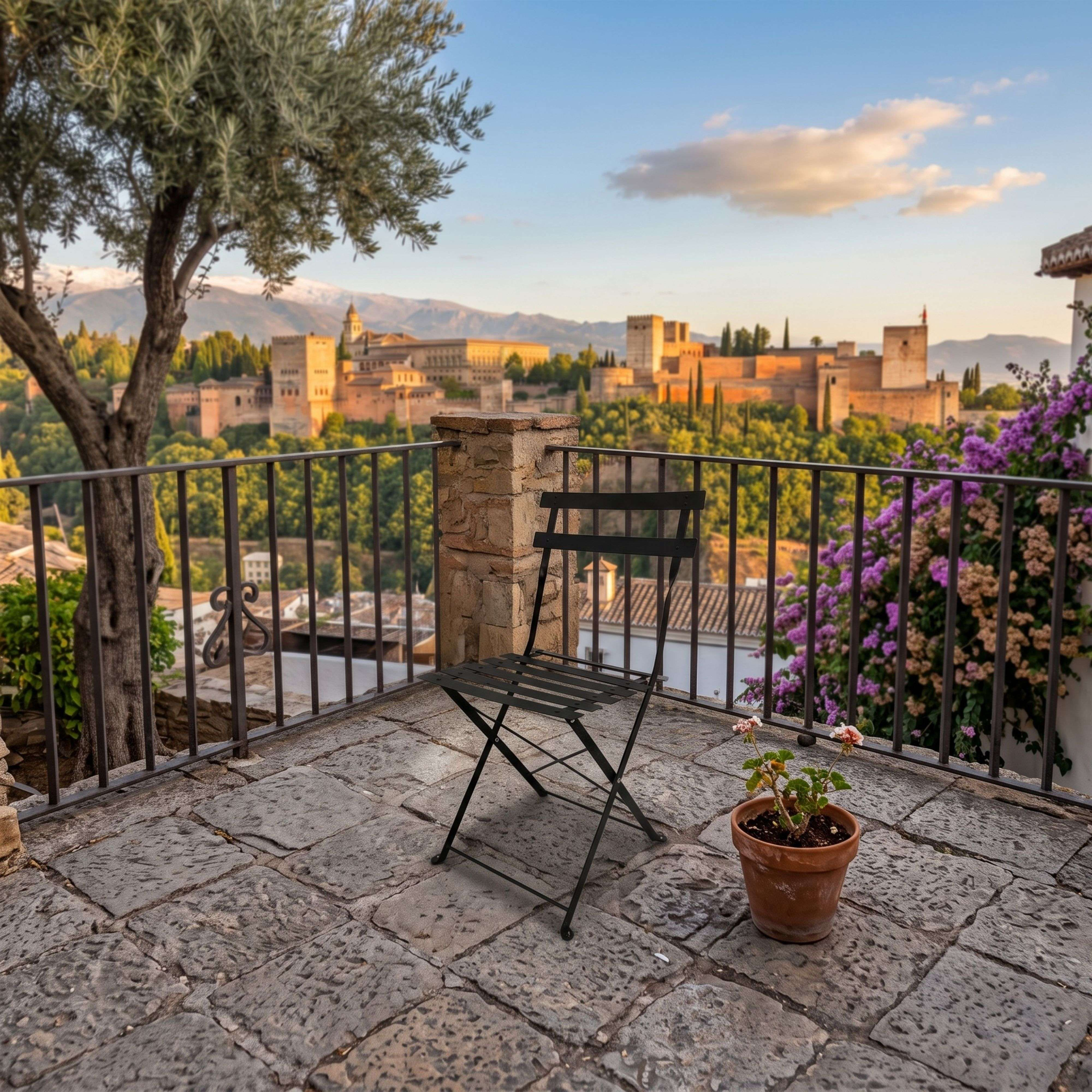 Una terraza con silla plegable y maceta, con vistas a la Alhambra.