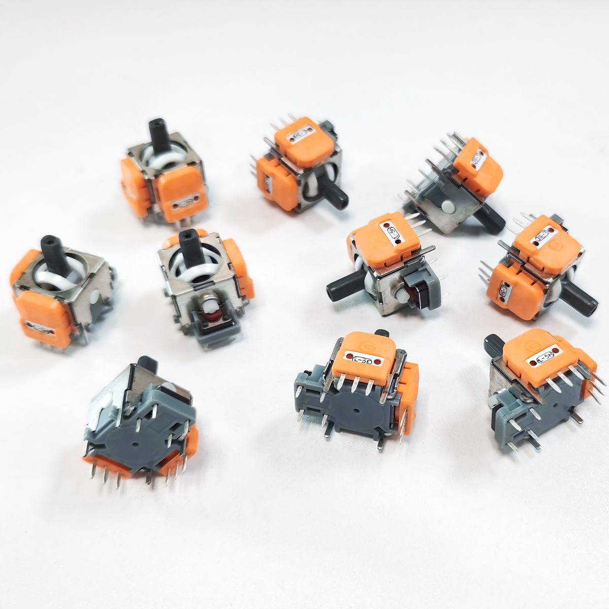 Mehrere orange-graue Joystick-Module mit Metallgehäuse auf weißem Hintergrund.
