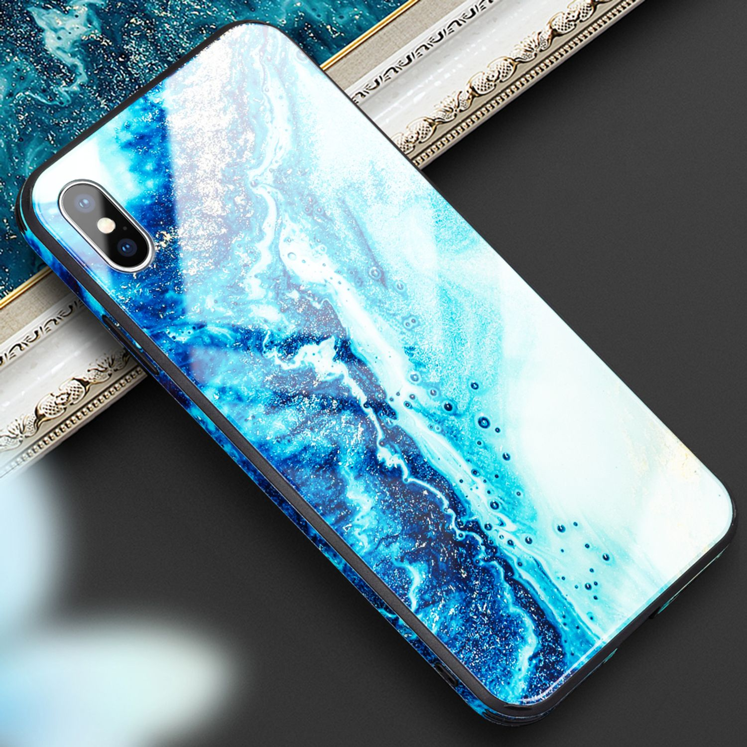 Ein Smartphone mit blauem Marmormuster liegt auf einem dunklen Hintergrund.