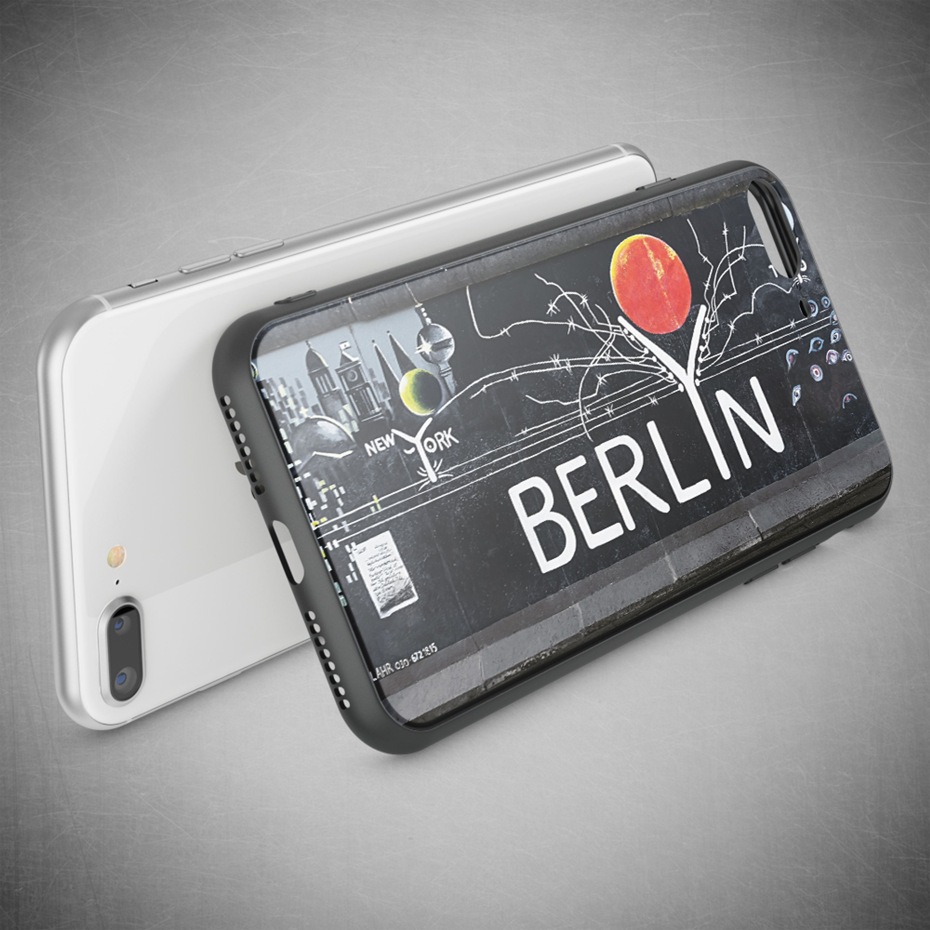 Ein silbernes Smartphone liegt hinter einer schwarzen Hülle mit dem Aufdruck Berlin.
