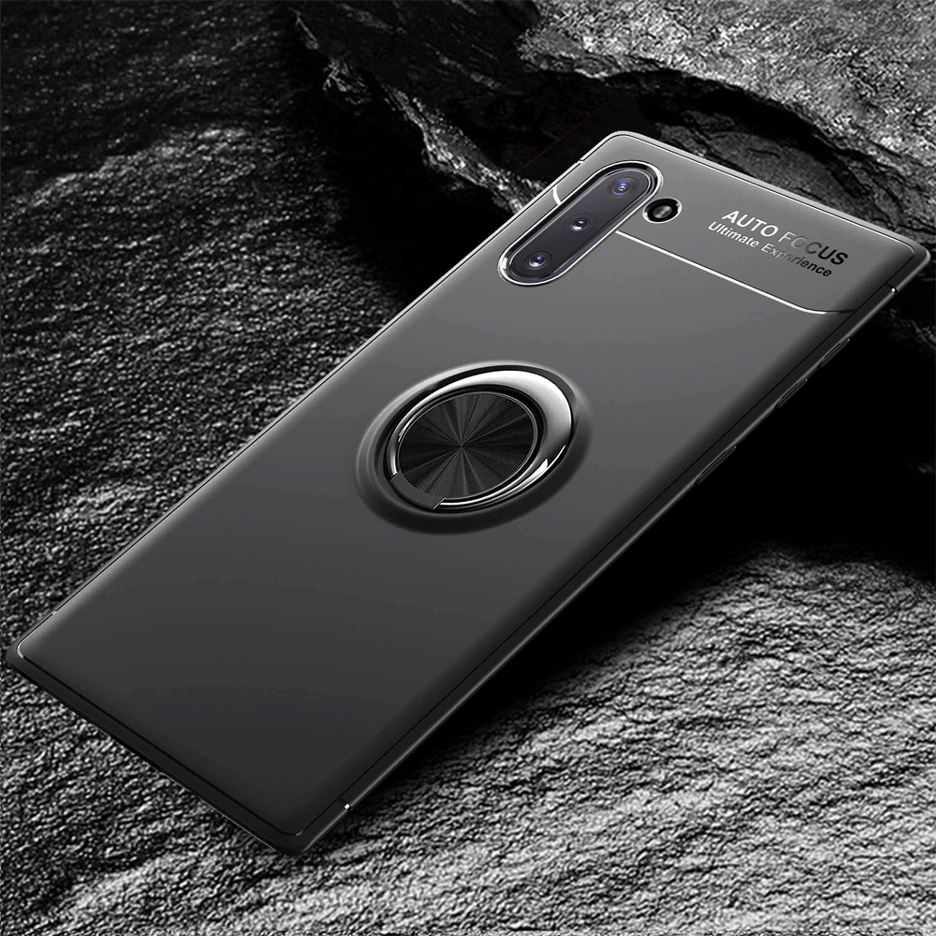 Dunkelgraues Handy mit Ringhalterung auf steinigem Untergrund.