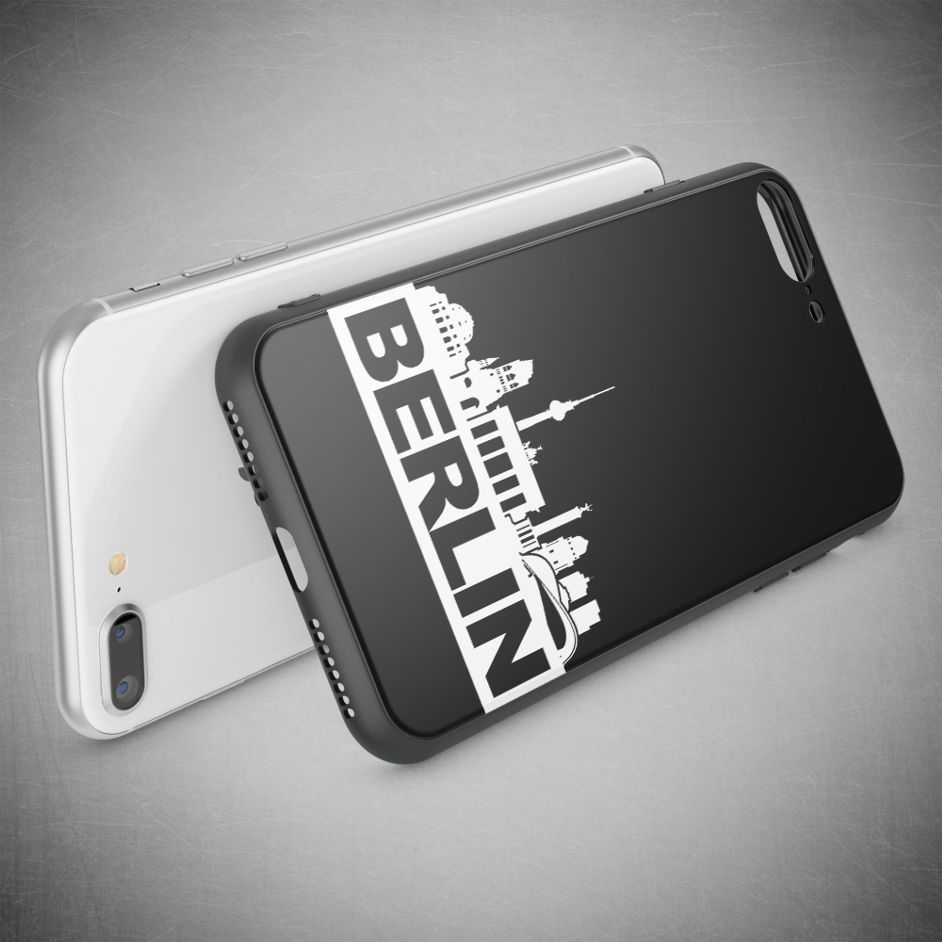 Ein weißes und ein schwarzes iPhone liegen nebeneinander auf grauem Untergrund.