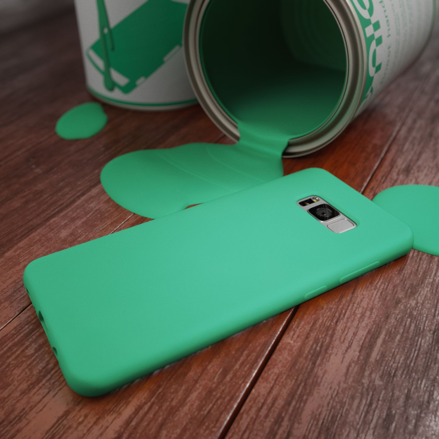 Eine grüne Farb dose kippt und verschüttet Farbe auf ein grünes Smartphone auf Holzboden.