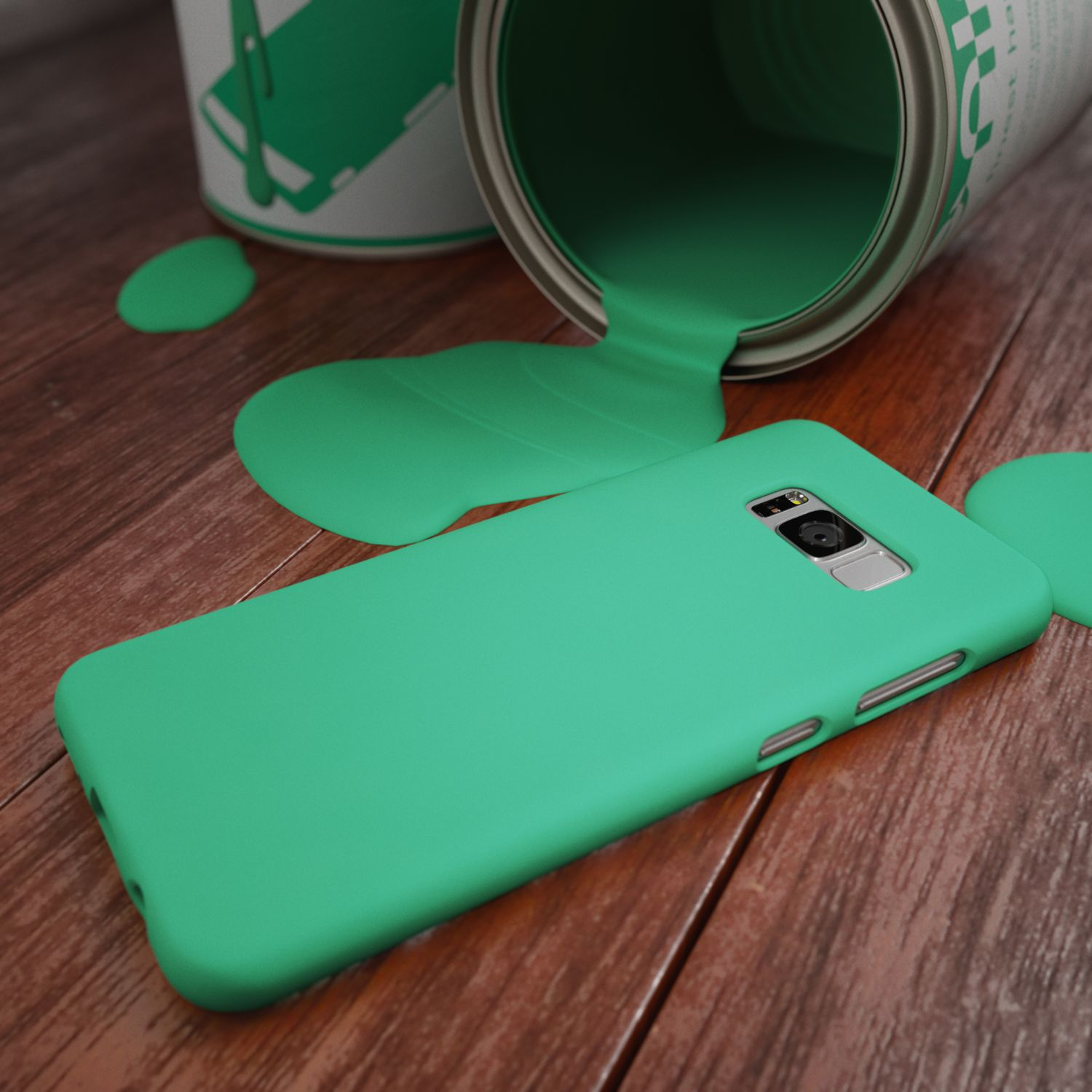 Grüne Farbe tropft aus einer Dose auf ein Smartphone auf Holzboden.