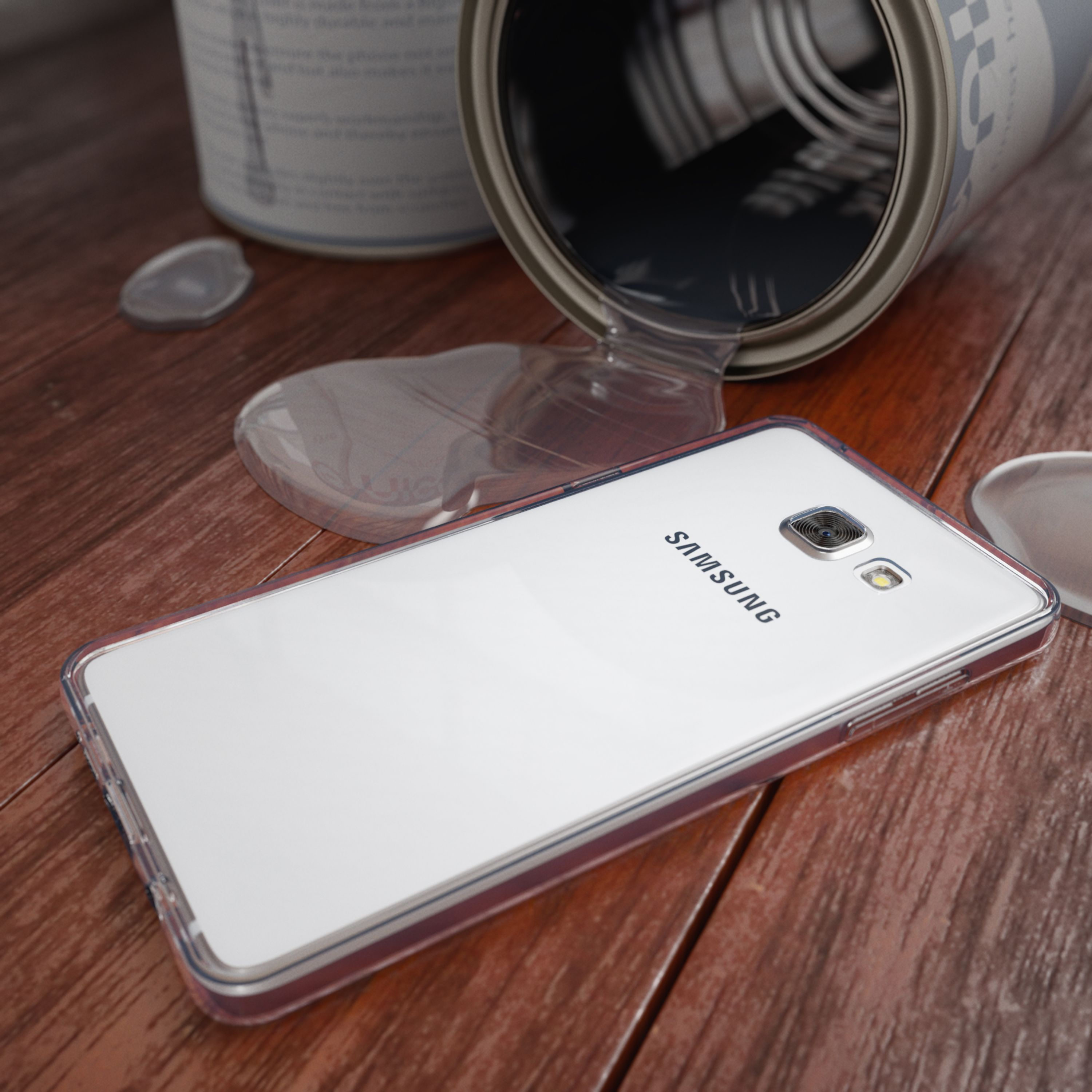 Ein offener Farbeimer ist umgekippt und verschüttet. Ein Smartphone liegt daneben.