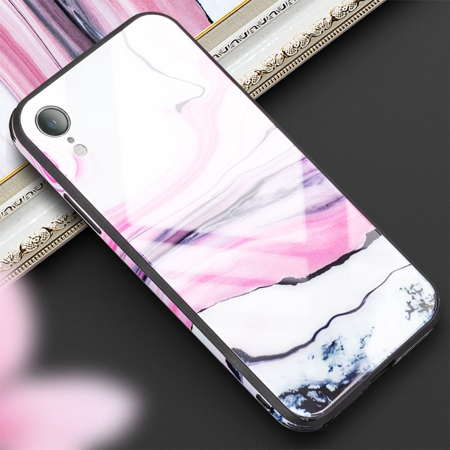 Ein weißes Smartphone mit Marmormuster in Rosa- und Grautönen, auf schwarzem Hintergrund.