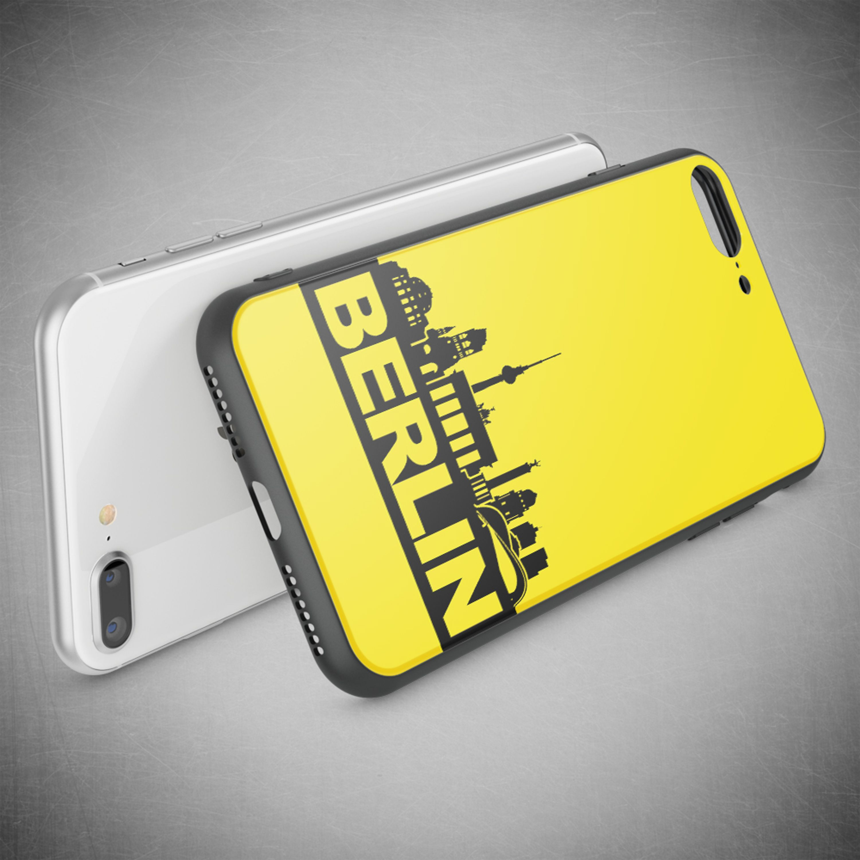 Zwei Smartphones auf grauem Hintergrund. Eines ist weiß mit Kameras, das andere gelb mit Berlin Skyline.