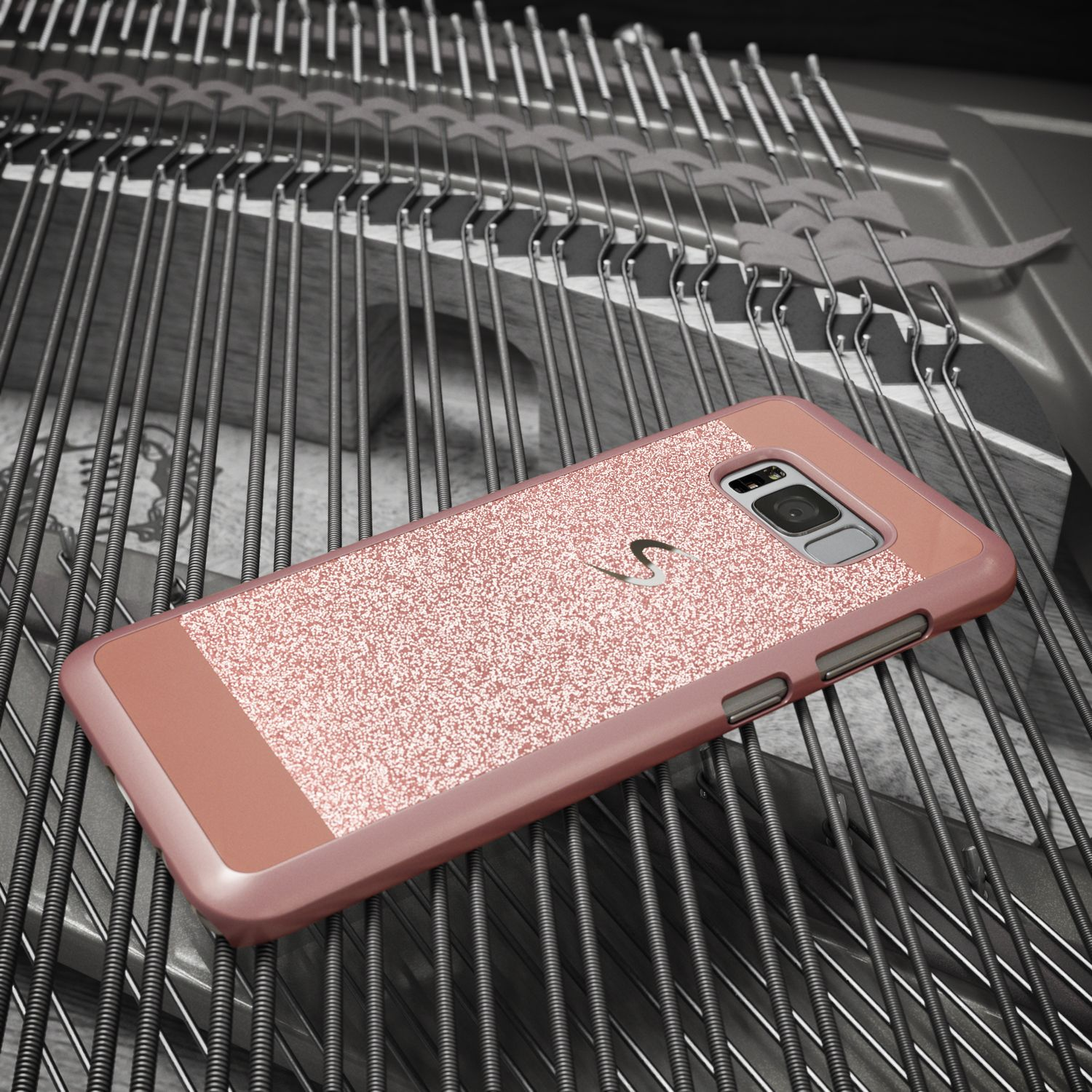 Ein roségoldenes Handy mit Glitzerhülle liegt auf Klaviersaiten.