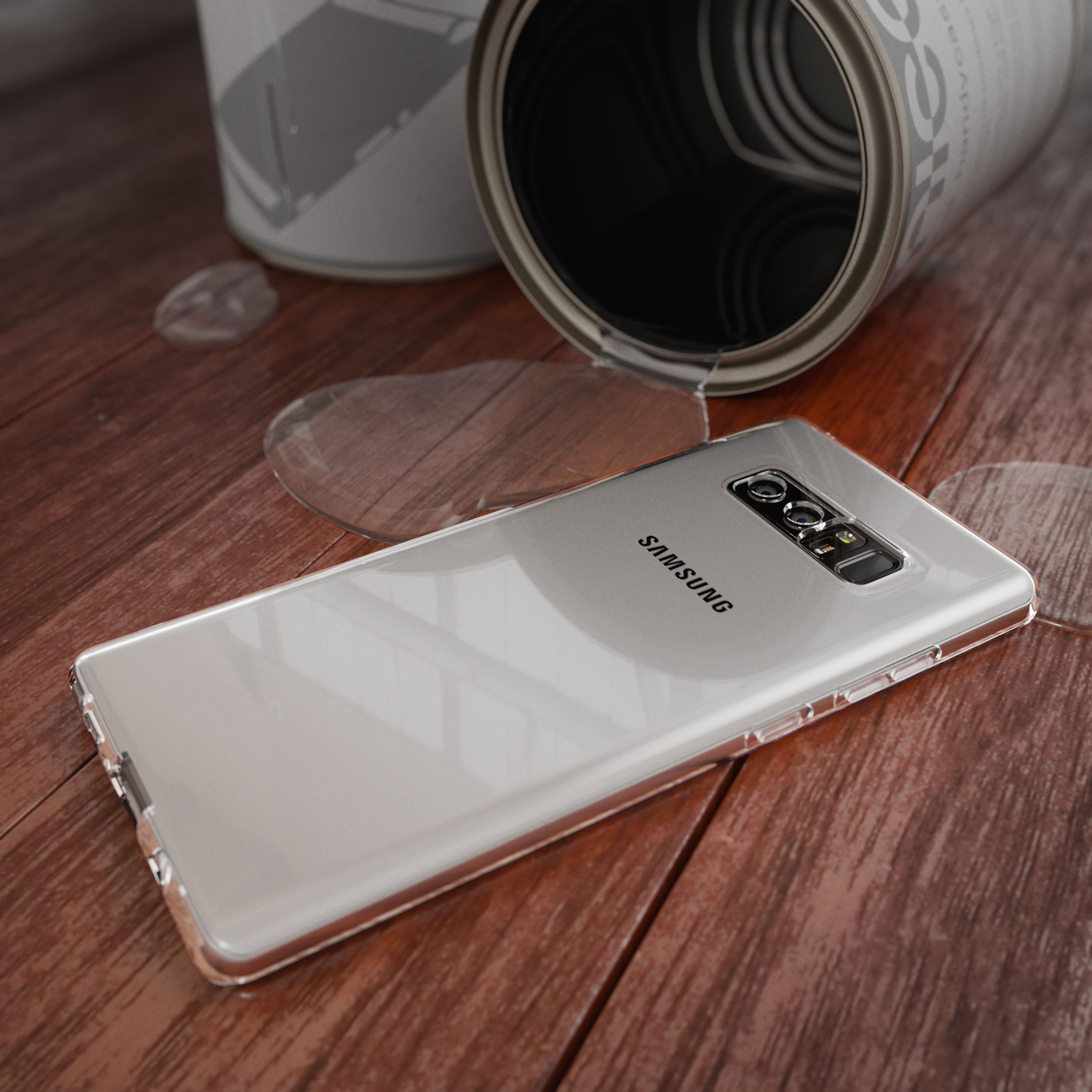 Ein Samsung-Handy liegt auf einem Holztisch neben einem umgekippten Farbeimer mit verschütteter Flüssigkeit.
