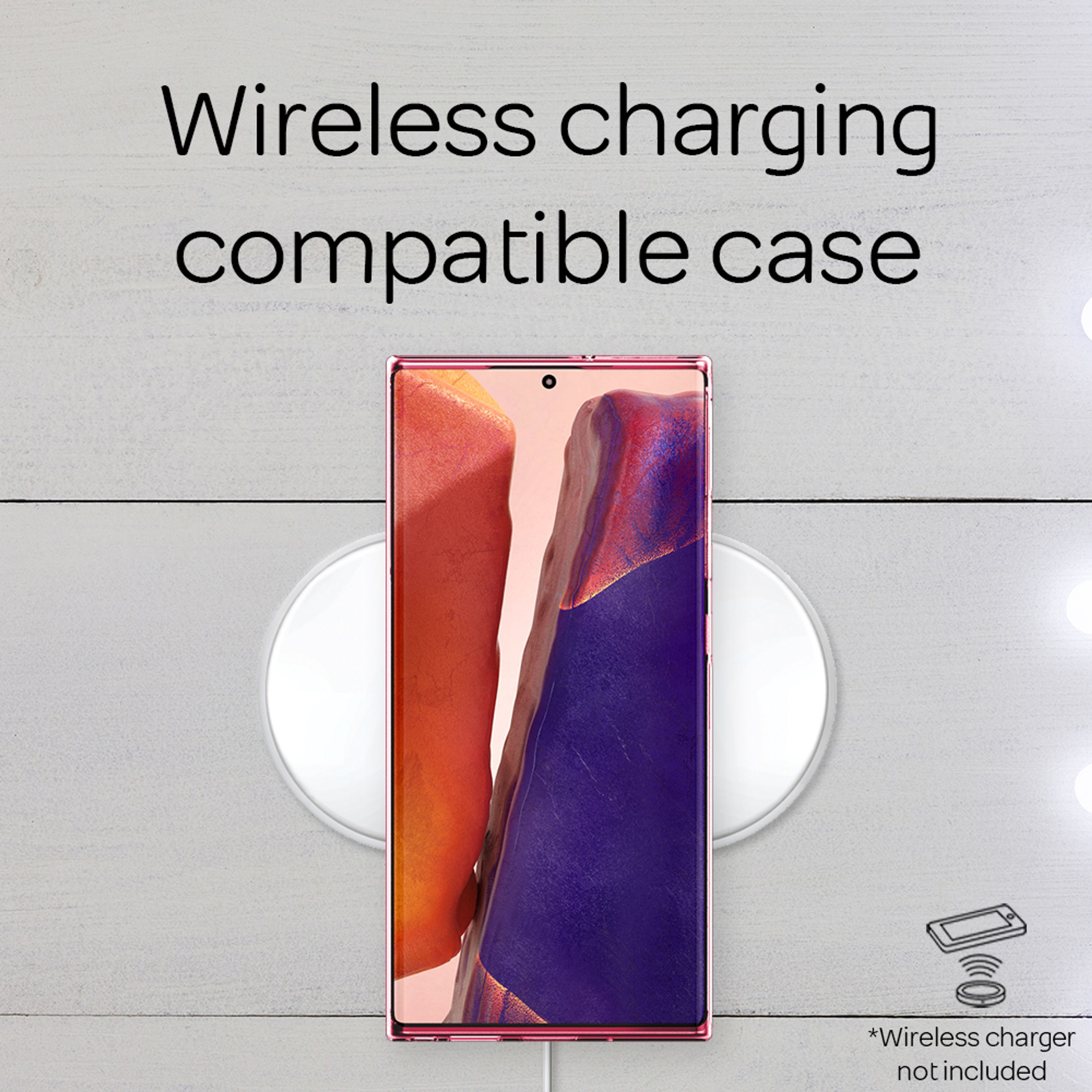 Un telefono rosa giace su un pad di ricarica bianco.