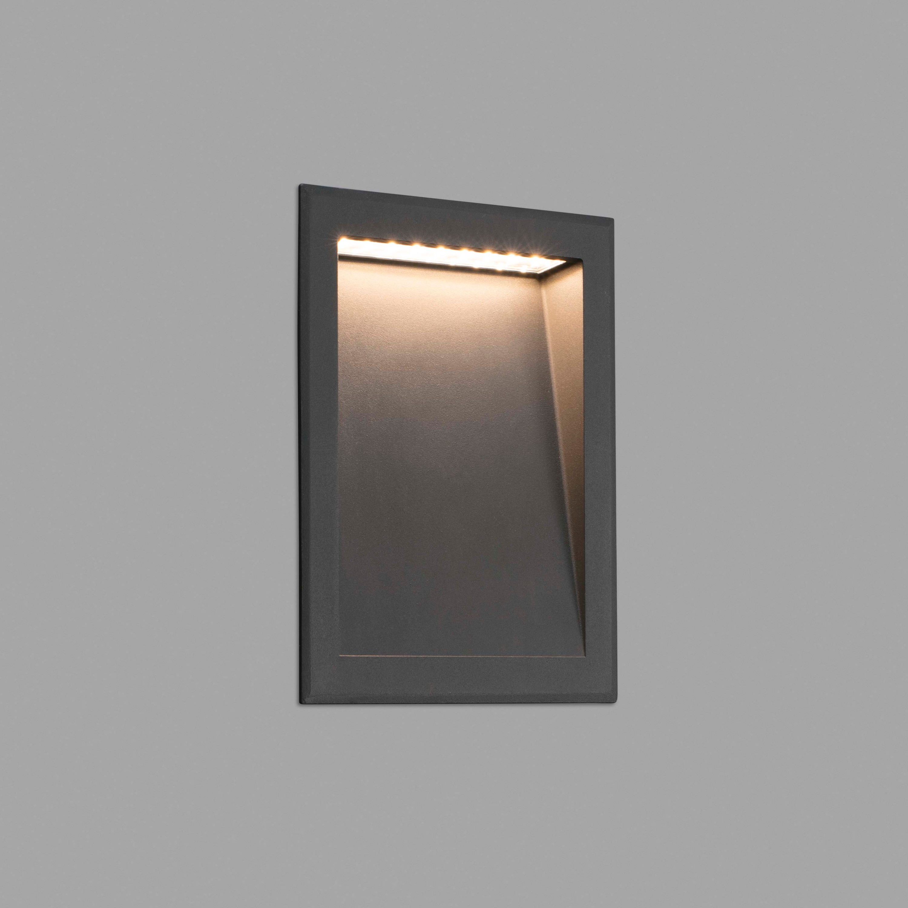 Un aplique empotrado oscuro con iluminación LED en el interior.