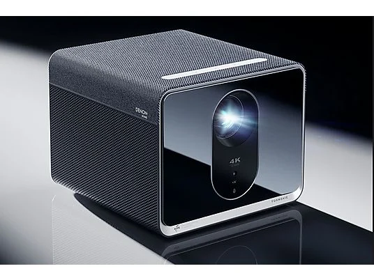 Ein schwarzer 4K-Projektor mit silbernen Akzenten steht auf einer glänzenden Oberfläche.