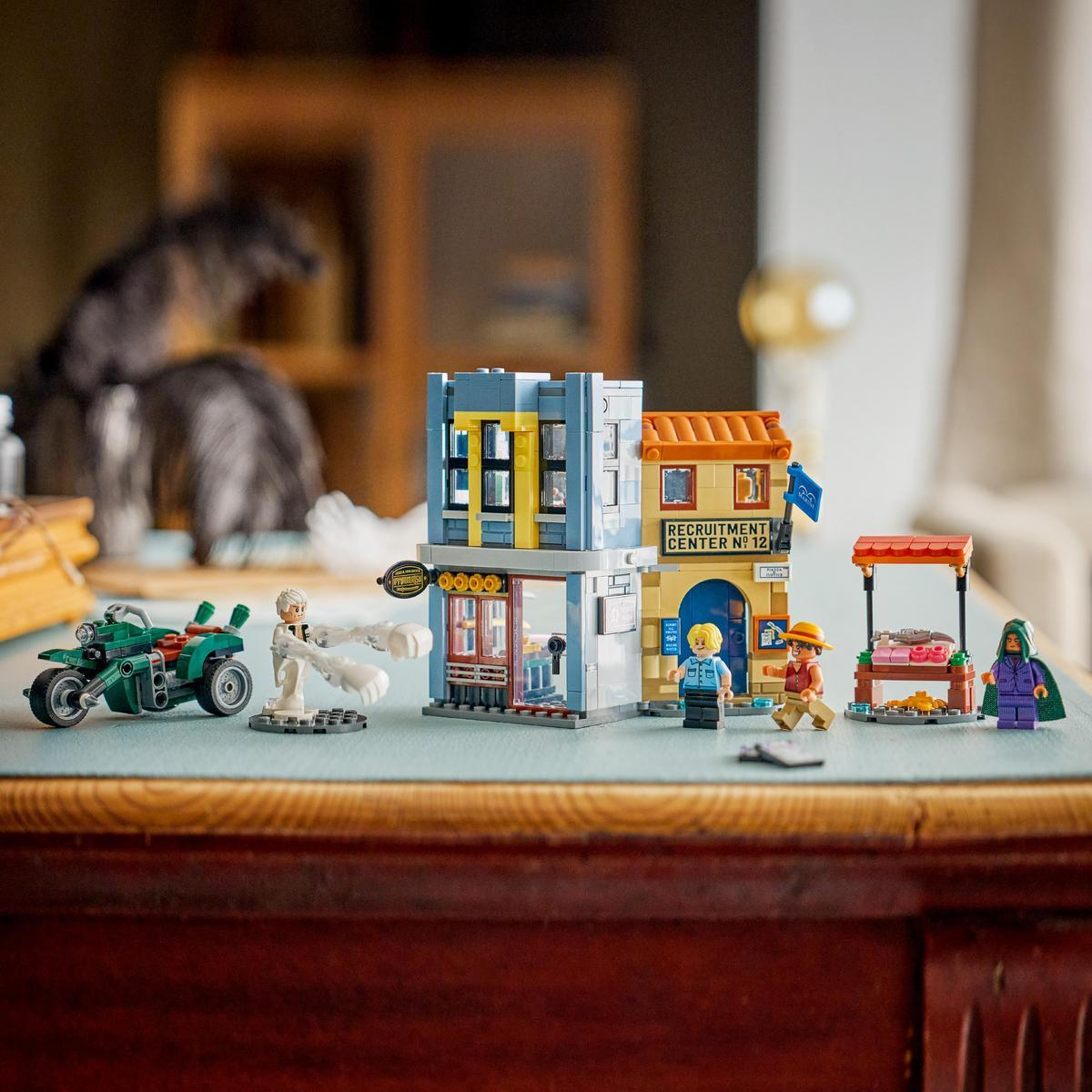 Figure Lego, una moto verde e edifici su un tavolo con sfondo sfocato.