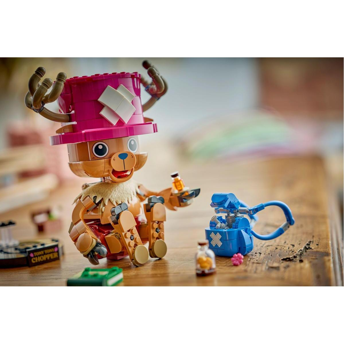 Un personaggio Lego marrone con cappello rosa siede su un tavolo di legno, tenendo una bottiglia.