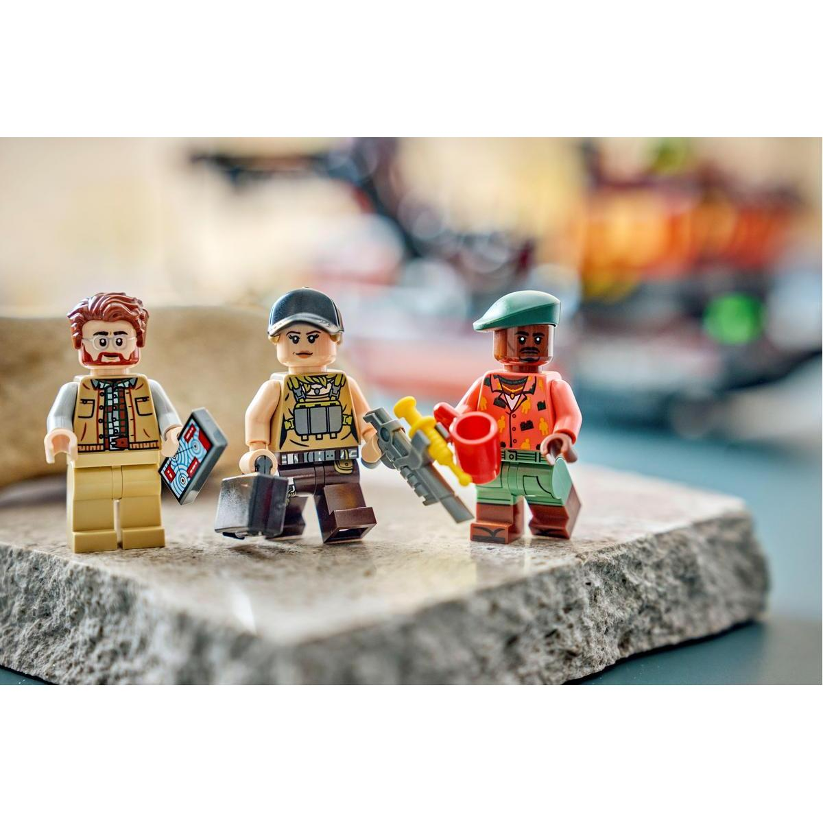 Tre figure Lego su una pietra. Una tiene una carta blu, la seconda una valigetta, la terza un annaffiatoio.