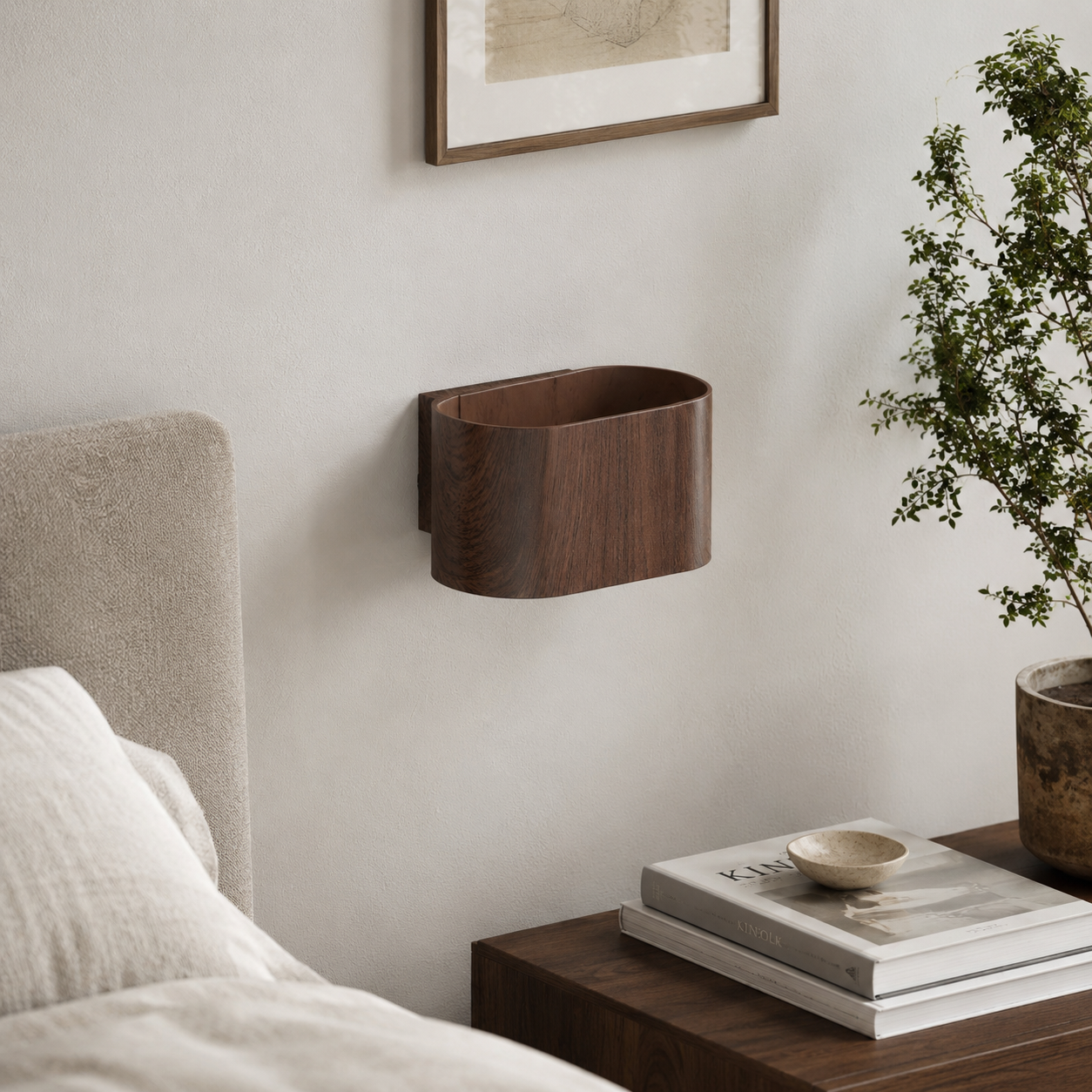Un contenedor de pared de madera sobre una mesita de noche con libros y una planta.