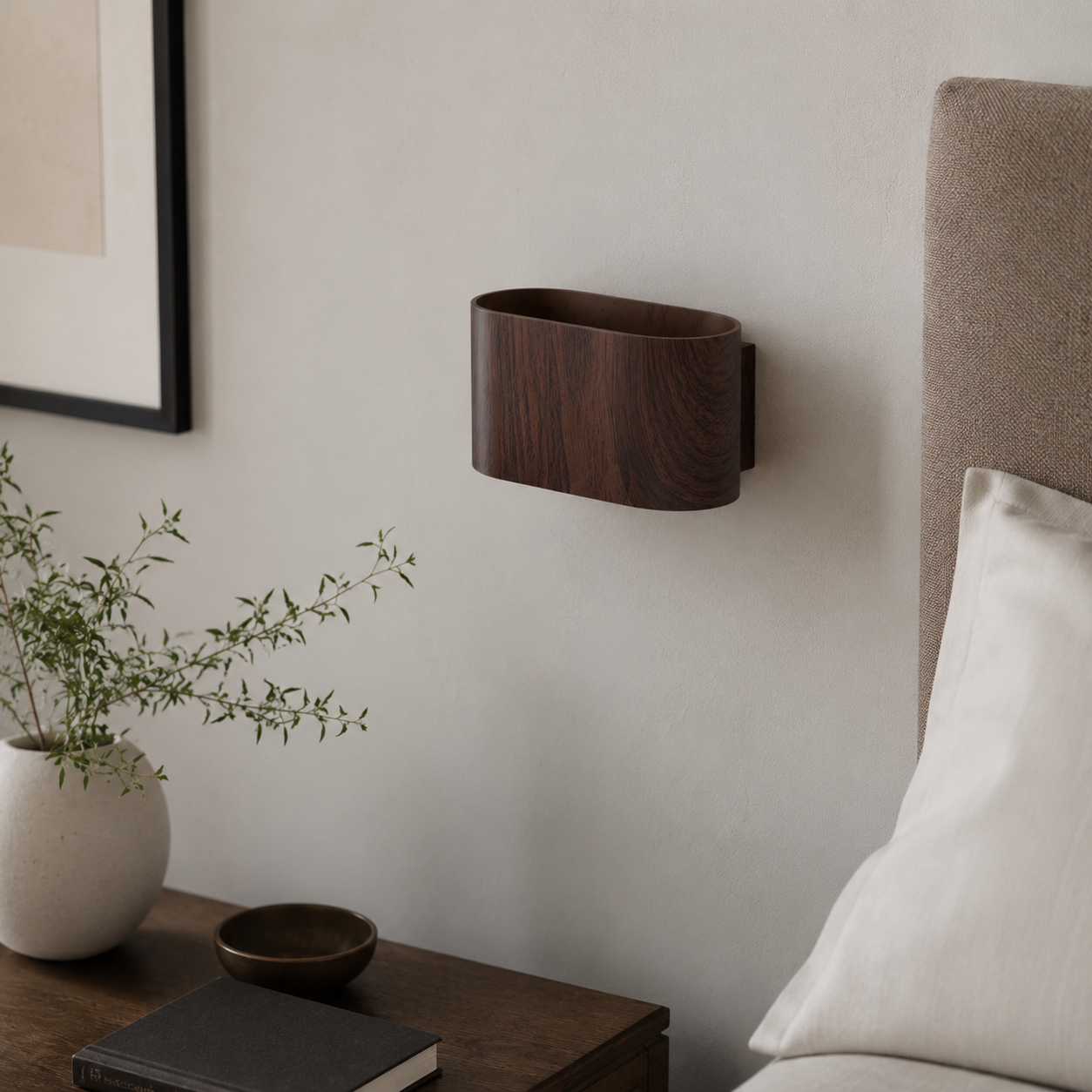 Una cesta de madera oscura en la pared sobre una mesita de noche con jarrón y libro.