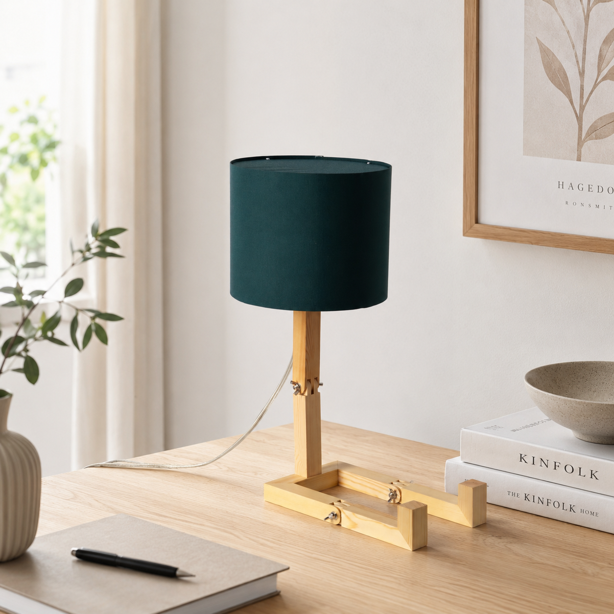 Lámpara de madera con pantalla verde oscuro sobre un escritorio con libros.