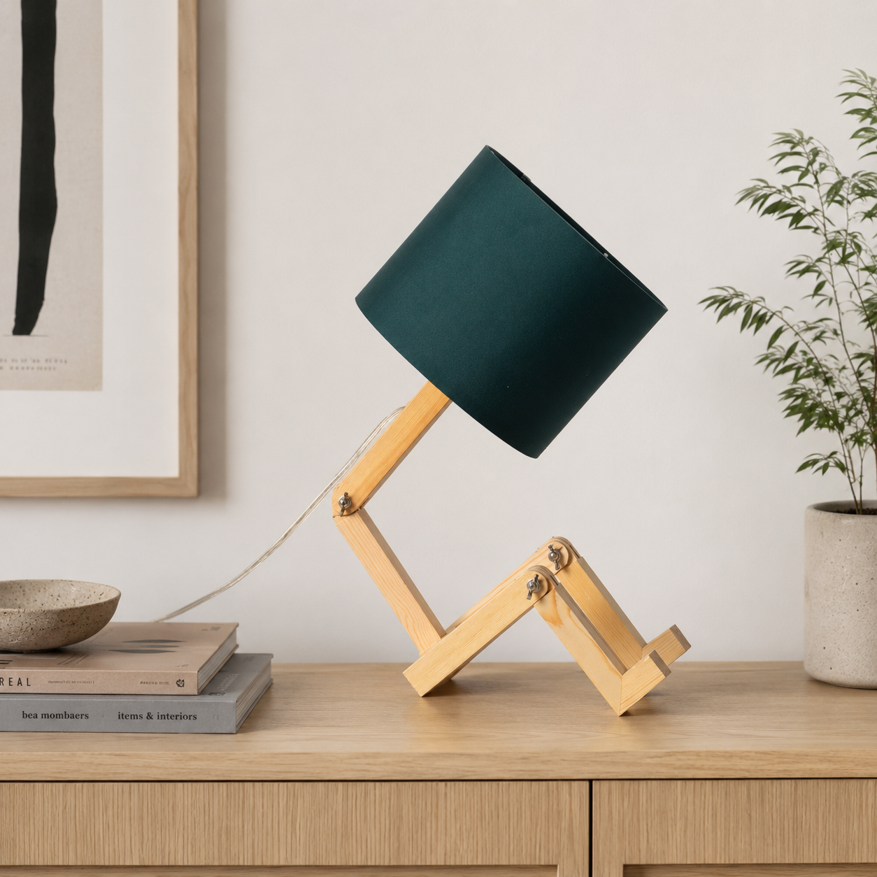 Una lámpara de escritorio de madera con pantalla verde oscuro sobre un mueble de madera.