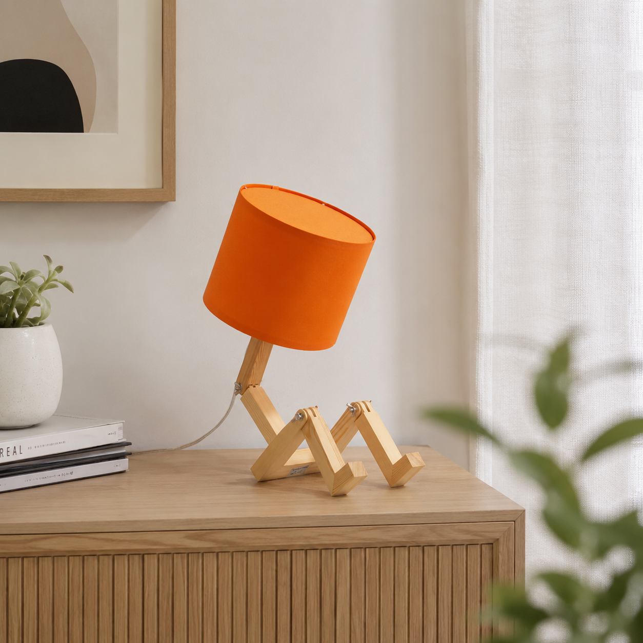 Una lámpara naranja con estructura de madera articulada sentada en una mesita de noche.
