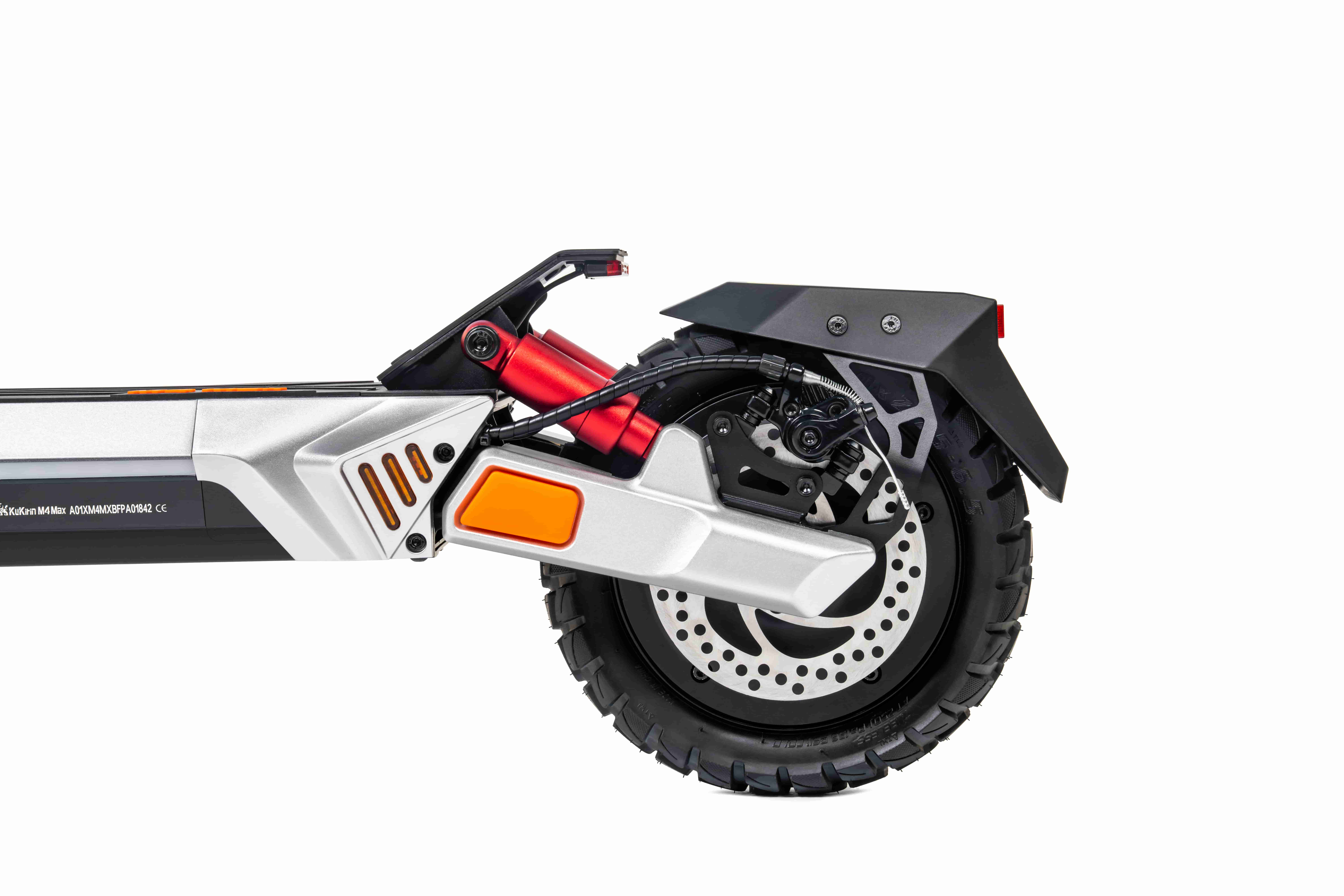 Primo piano della ruota posteriore di uno scooter elettrico, corpo argentato con ammortizzatori rossi.