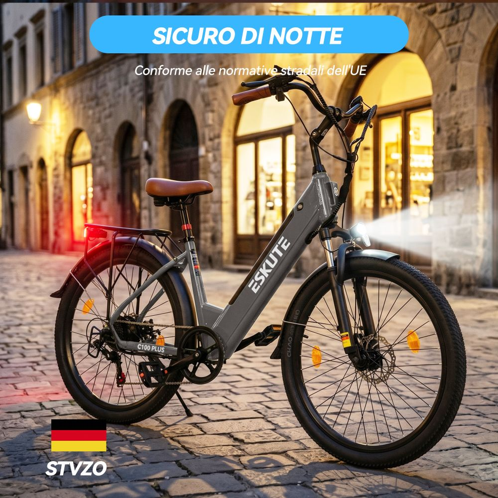 Bici elettrica grigia con sella marrone su strada acciottolata di notte.