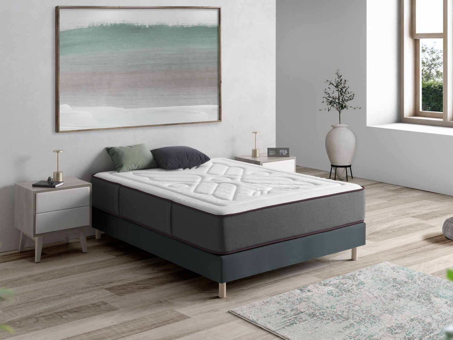 Un dormitorio moderno con un colchón en una cama, mesita de noche y arte abstracto.