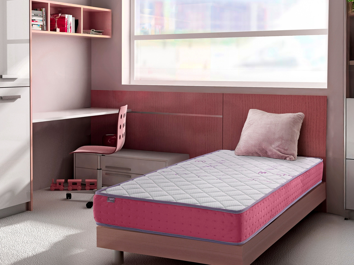 Habitación infantil con cama rosa, escritorio y tren de juguete.