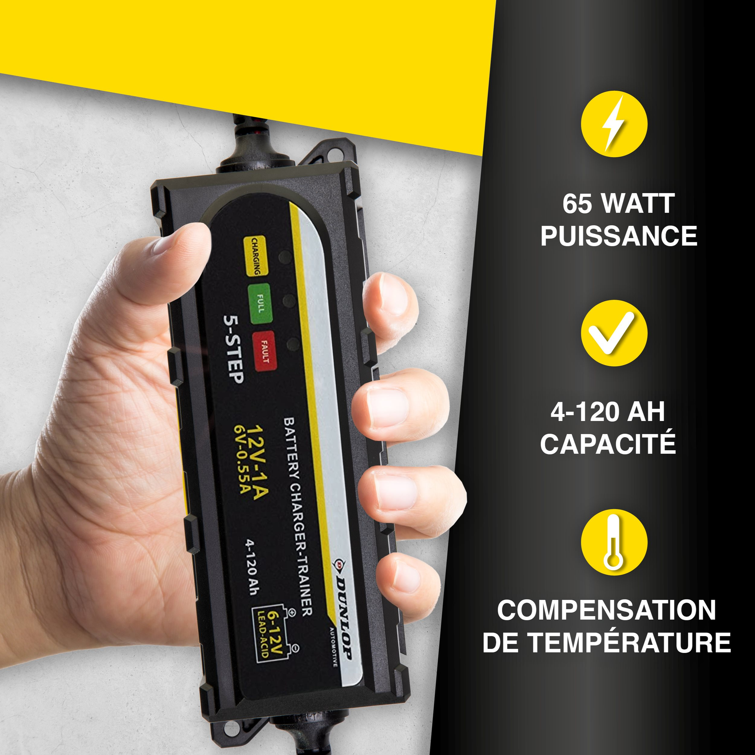 Een hand houdt een zwarte Dunlop 5-staps acculader vast met gele en groene lampjes.